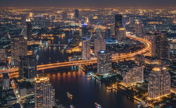 Toàn cảnh thành phố Bangkok về đêm với những tòa nhà chọc trời lung linh ánh đèn và dòng sông Chao Phraya uốn lượn.