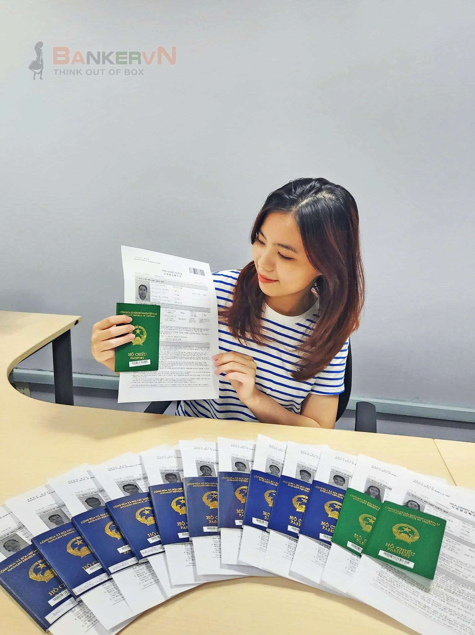 Nhân viên Banker.vn đang kiểm tra và xử lý một chồng hồ sơ hộ chiếu và visa của khách hàng tại văn phòng.