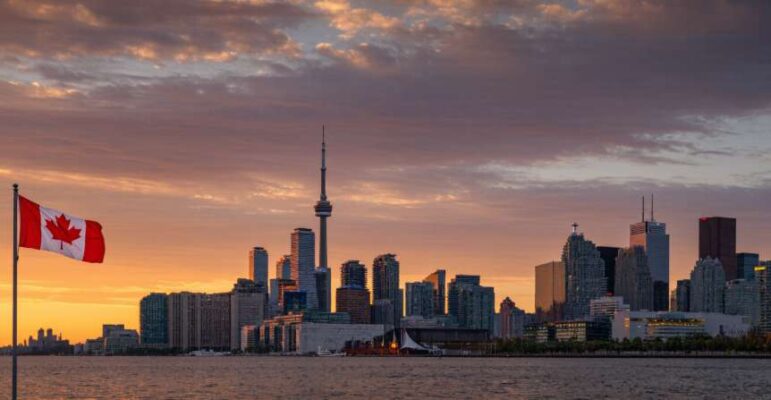 Toàn cảnh thành phố Toronto, Canada với tháp CN Tower lúc hoàng hôn, biểu tượng cho cơ hội học tập và làm việc.