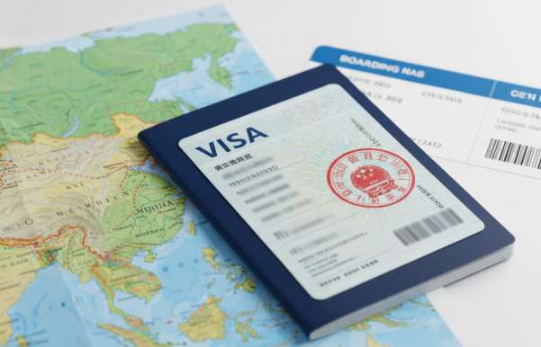 Hình ảnh hộ chiếu đã dán visa Trung Quốc, bên cạnh là vé máy bay và bản đồ du lịch Trung Quốc.