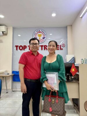Visa Top Ten Có Uy Tín Không? Tổng Hợp Đánh Giá Từ Khách Hàng 2026 16 Chuyên viên tư vấn của Visa Top Ten chụp ảnh cùng một khách hàng nữ đang mỉm cười hài lòng sau buổi tư vấn visa thành công tại văn phòng công ty.