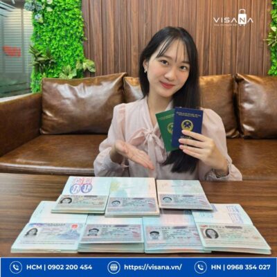 VISANA Có Uy Tín Không? Tổng Hợp Đánh Giá Từ Khách Hàng 2026 19 Nhân viên Visana cầm trên tay hộ chiếu và visa của khách hàng, phía trước là rất nhiều visa đã được cấp thành công, minh chứng cho dịch vụ uy tín.