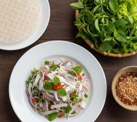 Đĩa gỏi cá trích Phú Quốc được trình bày đẹp mắt với cá tươi, dừa nạo, rau sống, bánh tráng và nước chấm.