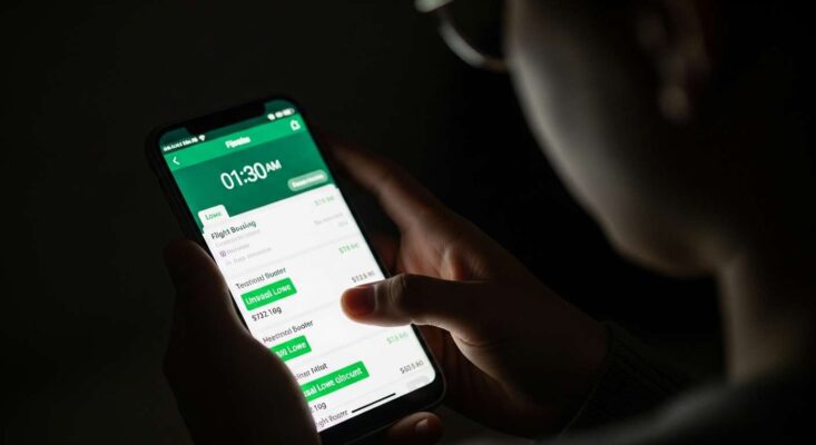 Một người đang săn vé máy bay giá rẻ trên điện thoại vào ban đêm, lúc 1:30 sáng.