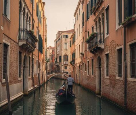 Một chiếc thuyền Gondola truyền thống đang lướt nhẹ trên một kênh đào nhỏ và lãng mạn ở Venice, Ý.
