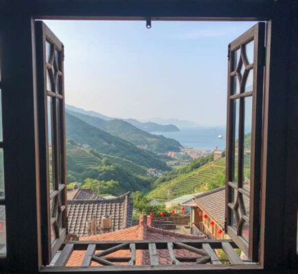 Khung cảnh biển xanh và núi non hùng vĩ nhìn từ cửa sổ một homestay bằng gỗ mộc mạc ở Cửu Phần