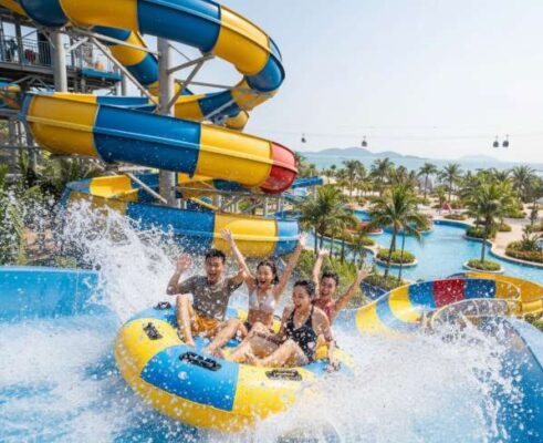Du khách đang hò reo phấn khích khi trượt xuống từ một đường trượt nước lớn tại công viên nước VinWonders Nha Trang.